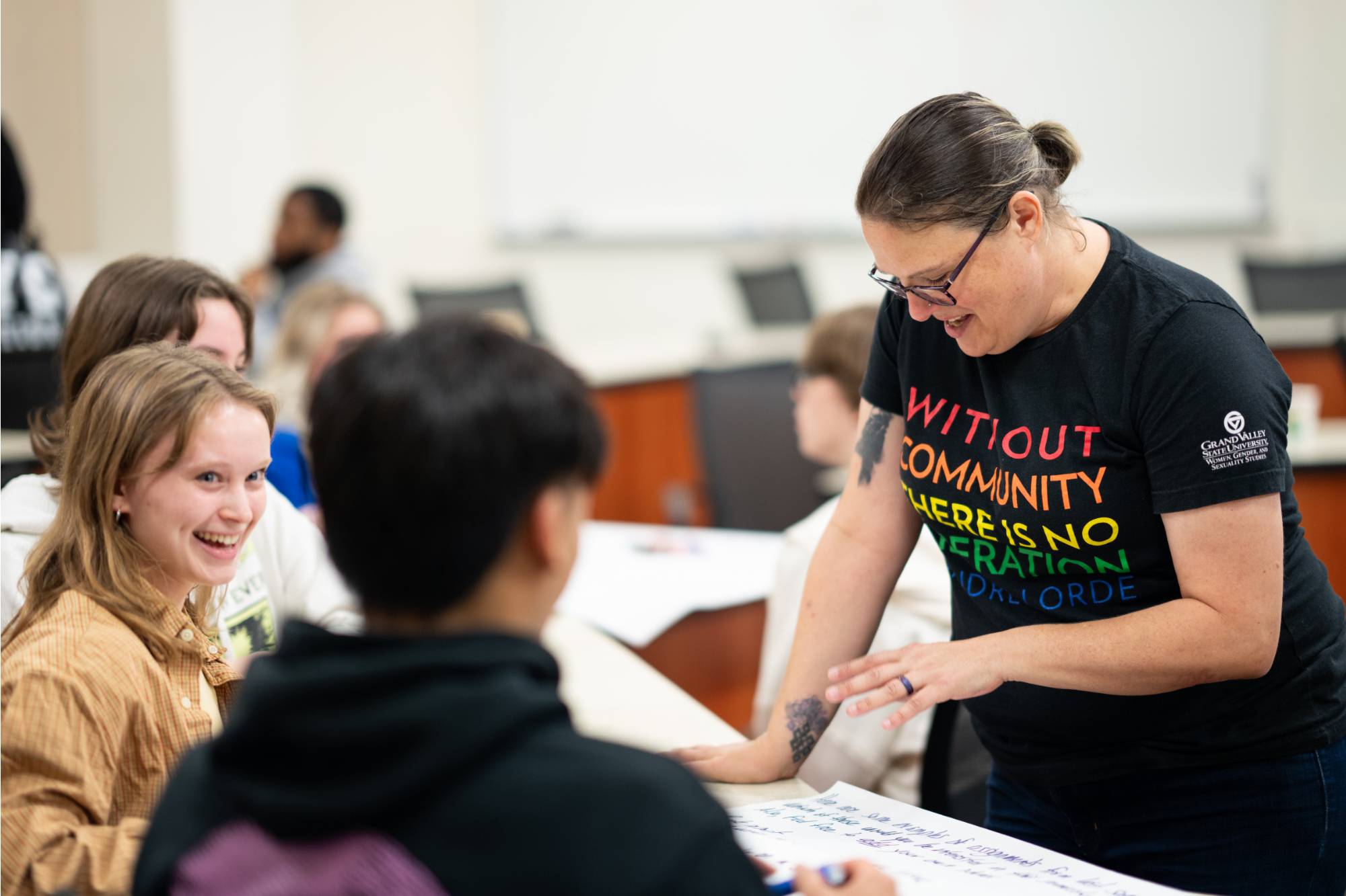 A photo of a teacher smiling in a classroom of smiling students